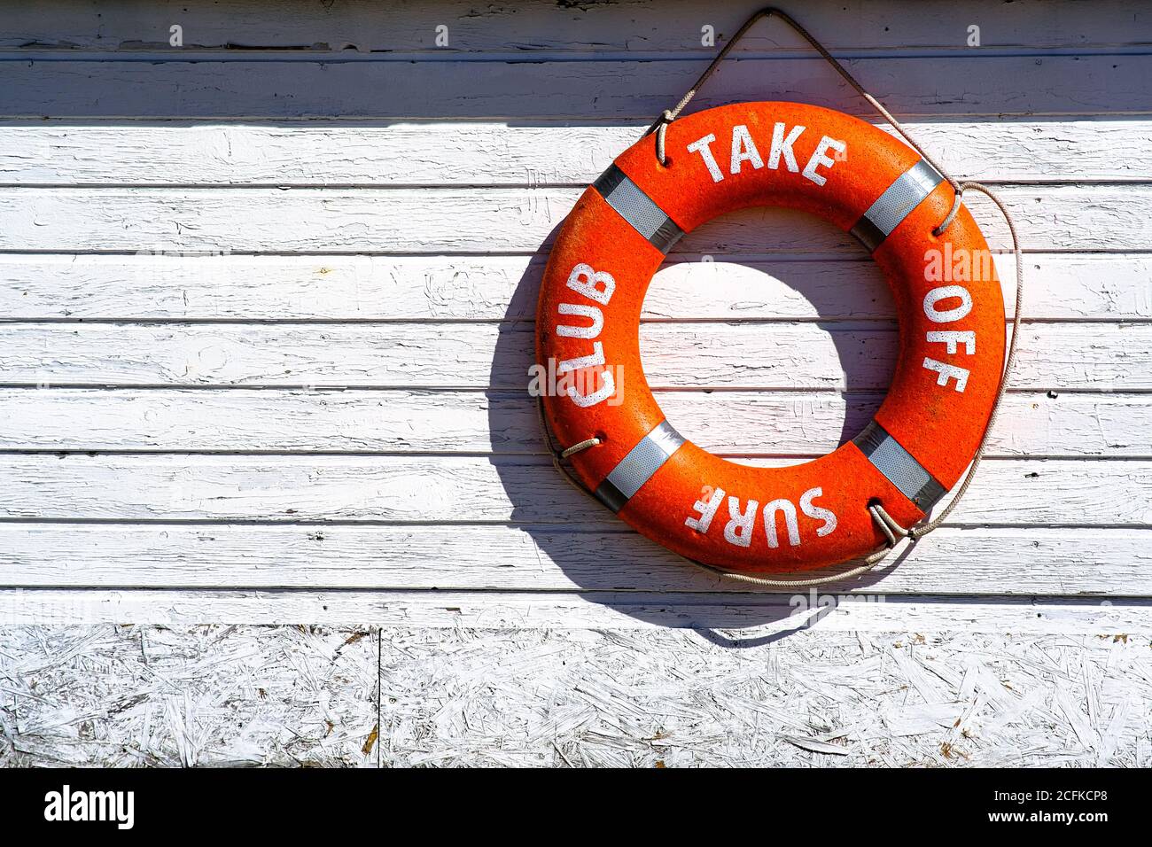 Galleggiante di salvataggio arancione. Lifebuoy sul muro dell'edificio della stazione di soccorso Foto Stock