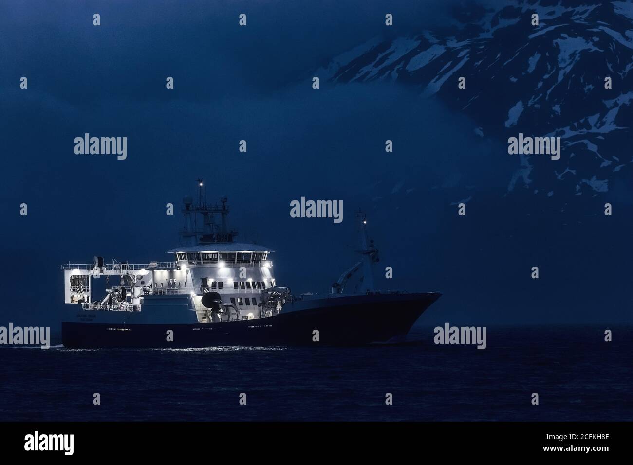 La nave da pesca commerciale si dirige verso Eskifjörður di notte in Islanda Foto Stock