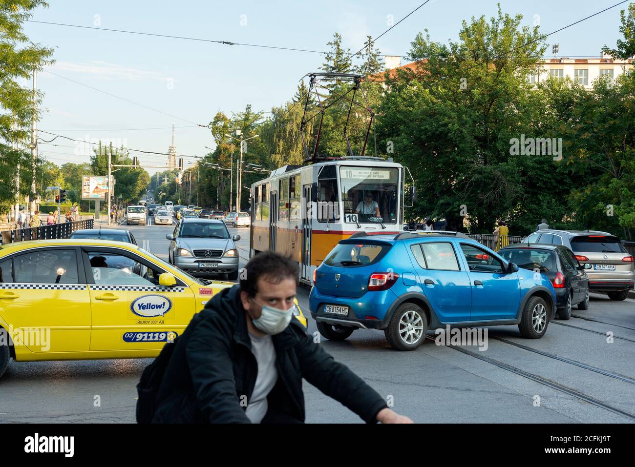 Sofia Bulgaria scena urbana trafficata durante l'ora di punta con il traffico delle auto tranvida pendolari e ciclisti Foto Stock