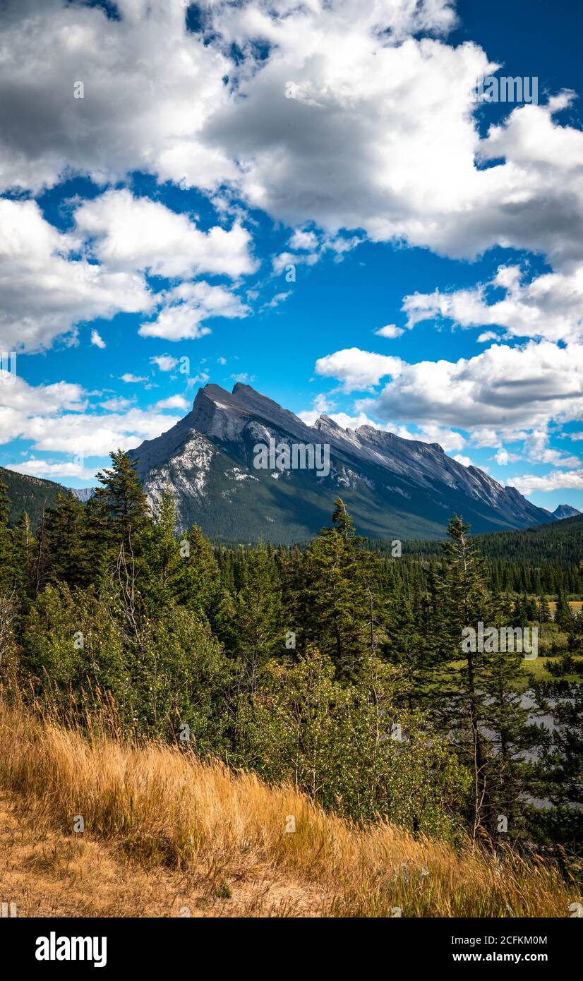 Monte Rundle con cielo blu brillante e nuvole drammatiche. Foto Stock