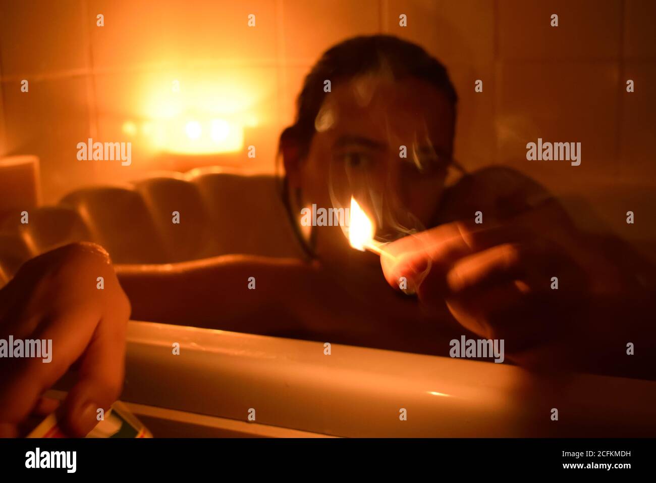 Persona che illumina una partita in una vasca da bagno Foto Stock