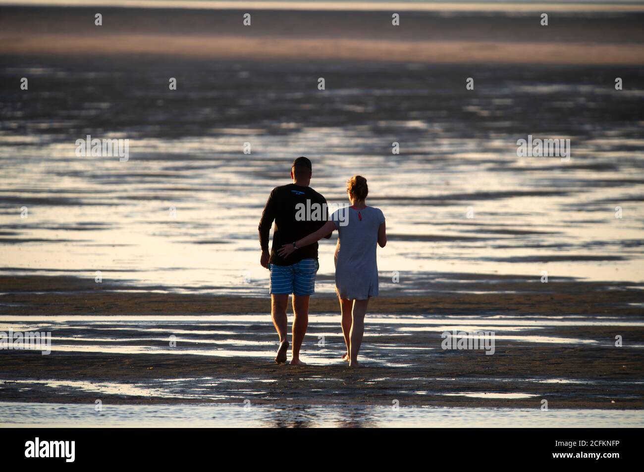 Una coppia che cammina lungo una spiaggia di Cape Cod a bassa marea. Chapin Beach, Dennis, Massachusetts su Cape Cod, Stati Uniti Foto Stock