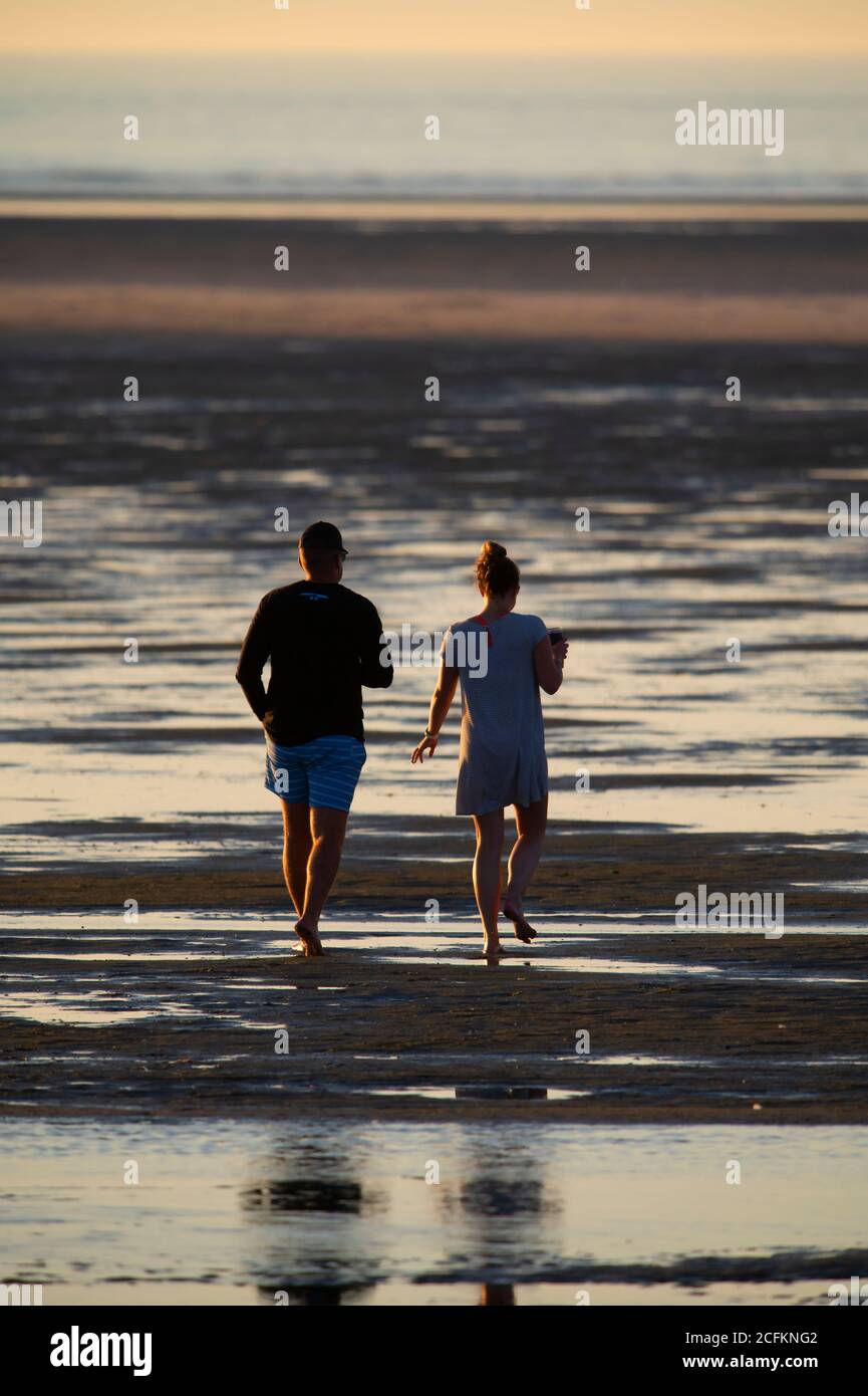 Una coppia che cammina lungo una spiaggia di Cape Cod a bassa marea, Chapin Beach, Dennis, Mass., USA Foto Stock