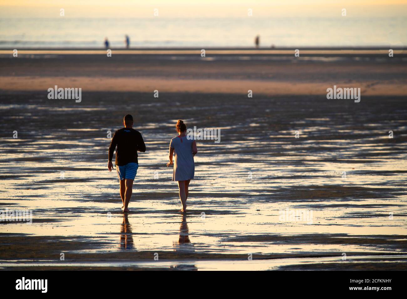 Una coppia che cammina su una spiaggia di Cape Cod a bassa marea. Chaping Beach, Dennis, Mass. USA Foto Stock
