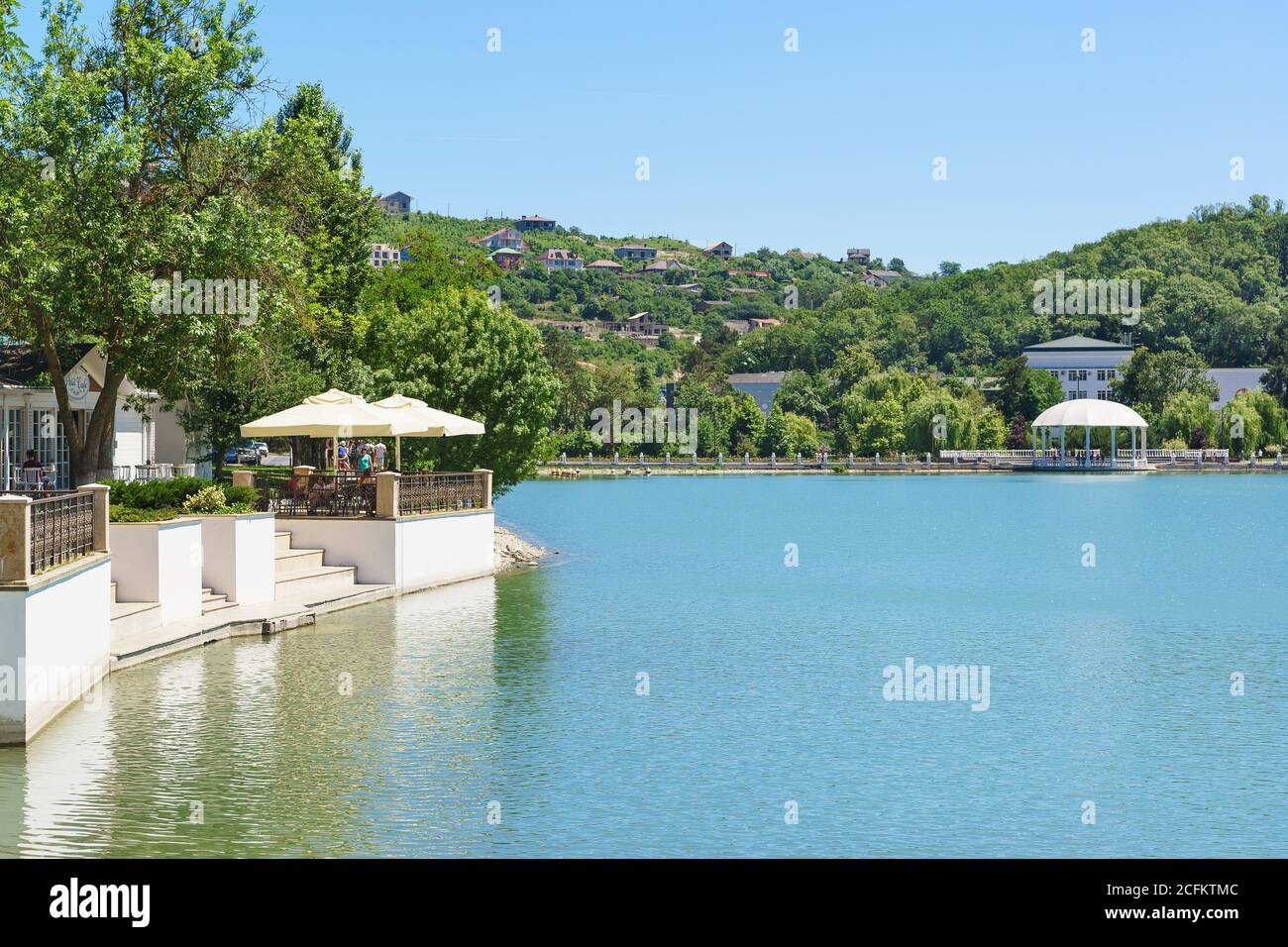 Russia, regione di Krasnodar, Novorossiysk, Abrau-Durso - 12 giugno 2018: molo e caffè estivo sulla riva del lago Abrau nel villaggio turistico. soleggiato summ Foto Stock