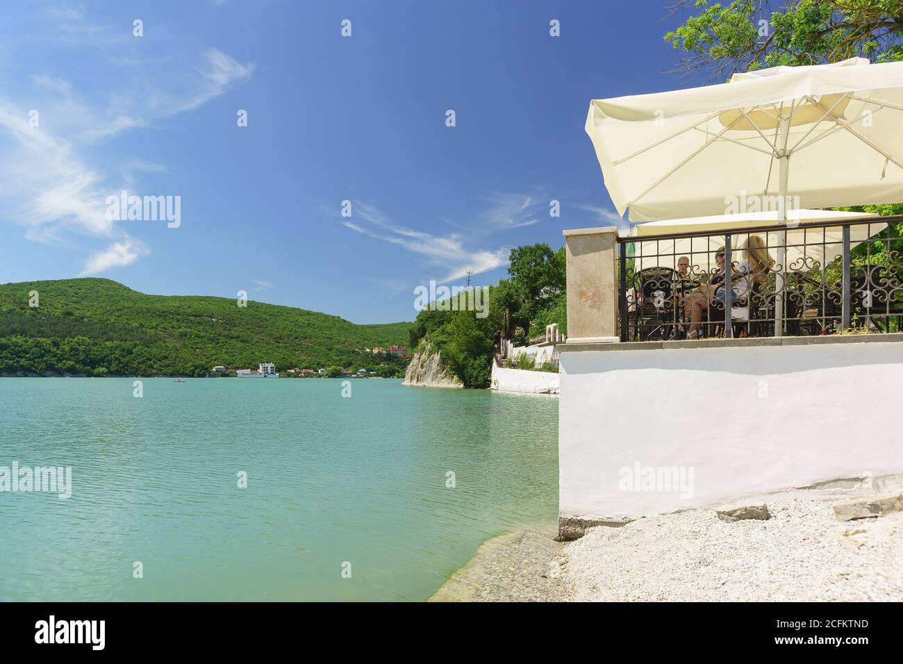 Russia, regione di Krasnodar, Novorossiysk, Abrau-Durso villaggio - 12 giugno 2018: Caffè estivo sulla riva del pittoresco lago di montagna Abrau. Giorno di sole Foto Stock