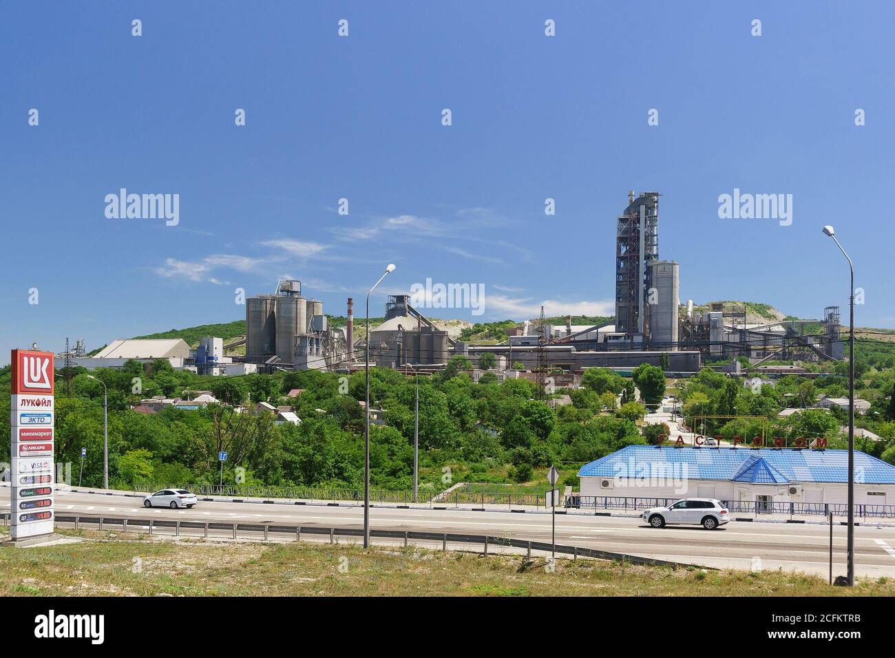 Russia, regione di Krasnodar, insediamento di Verkhnebakansky - 12 giugno 2018: Edifici di produzione dell'impresa di formazione urbana Verkhnebakansky cementificio Foto Stock