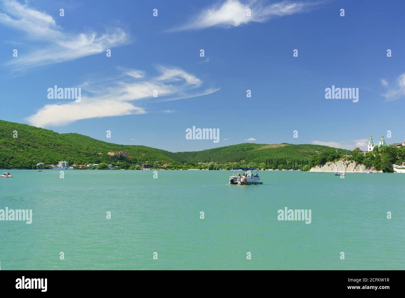 Russia, regione di Krasnodar, Novorossiysk, Abrau-Durso villaggio - 12 giugno 2018: I turisti cavalcano su una piccola barca sul pittoresco lago di montagna Abrau. Sole Foto Stock