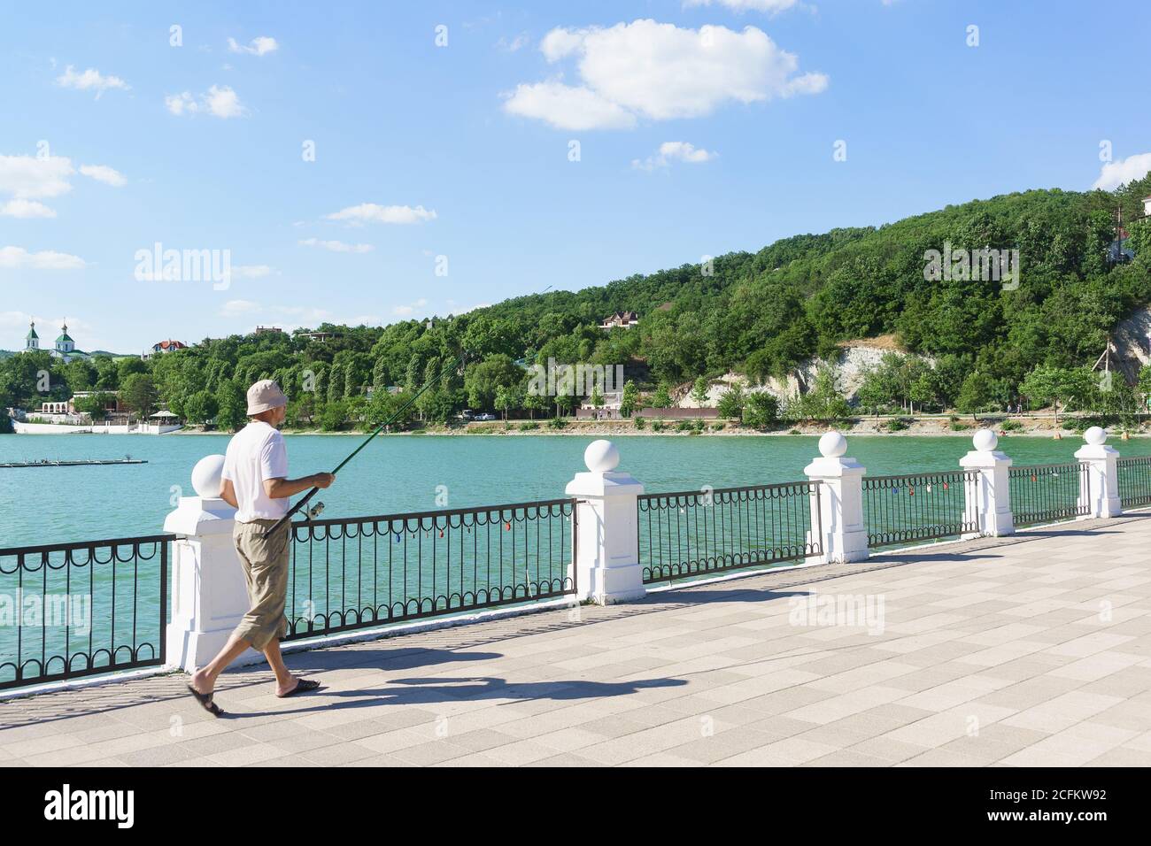 Russia, regione di Krasnodar, Novorossiysk, Abrau-Durso villaggio-12 giugno 2018: Pescatore con una canna da pesca si trova sul lungomare del pittoresco lago A. Foto Stock
