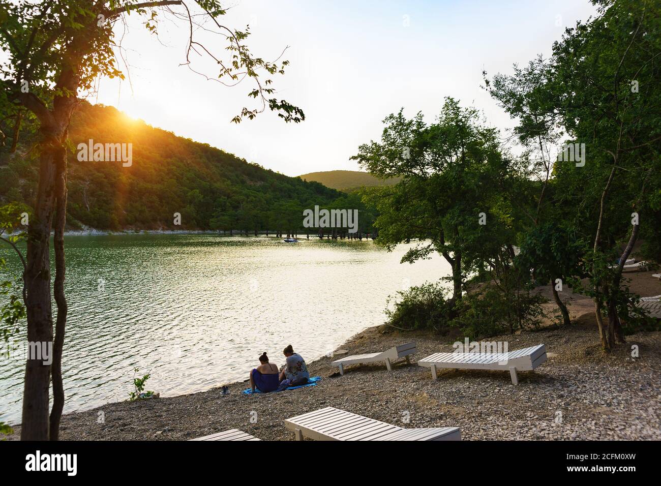 Lago di Sukko, regione di Krasnodar, Russia - 06 luglio 2019: Le persone si rilassano sulla riva dopo il bagno nel lago di Cypress. Tramonto Foto Stock