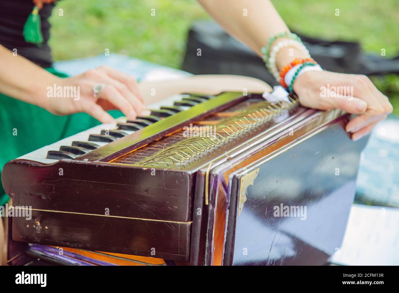 Mani femminili all'aperto che suonano sullo strumento musicale Shruti box Foto Stock