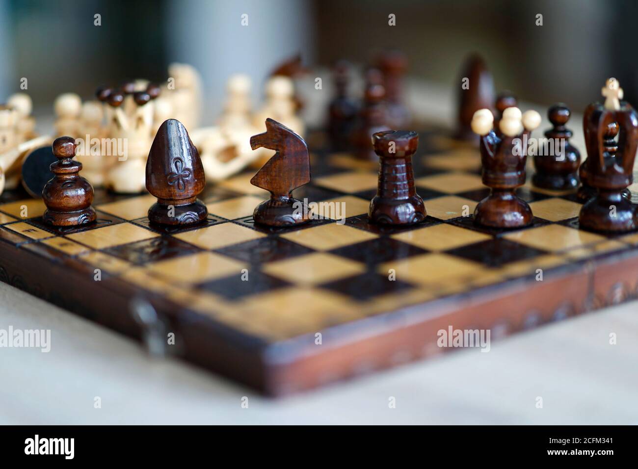 Pezzi di scacchi su tavola di gioco in legno. I pezzi includono la pedina, il re, la regina, il vescovo, il cavaliere e il rook Foto Stock