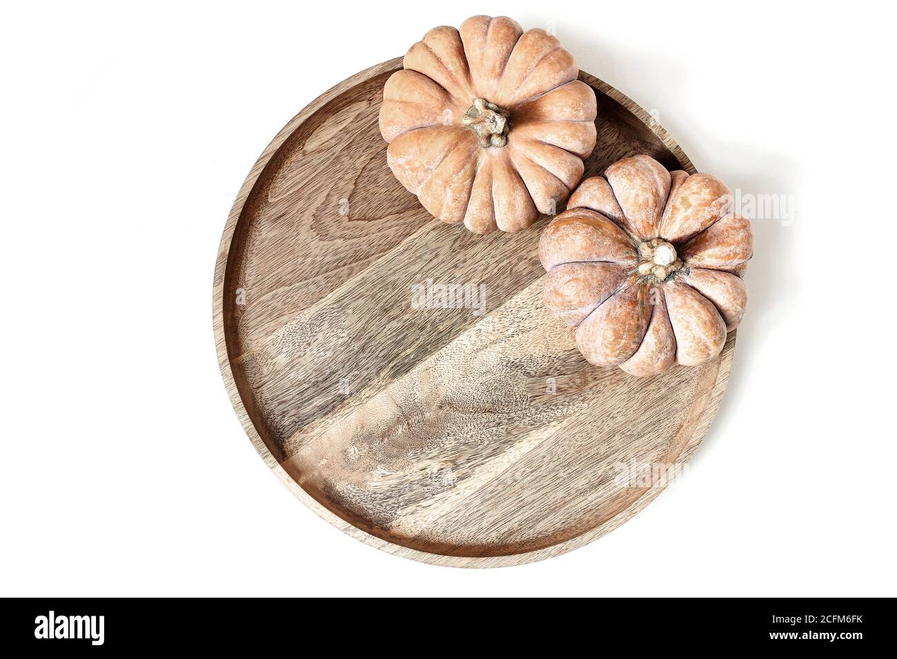 Composizione autunnale. Zucche arancioni su vassoio di legno, piastra isolata su sfondo bianco tavolo. Concetto di autunno, Halloween e Ringraziamento. Stile autunnale Foto Stock
