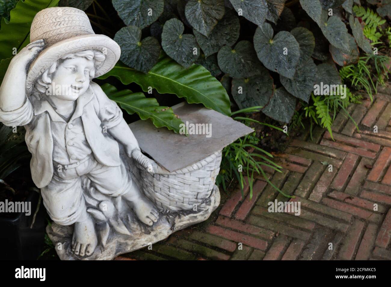 Giardino verde decorato con bambola di ragazzino, foto di scorta Foto Stock