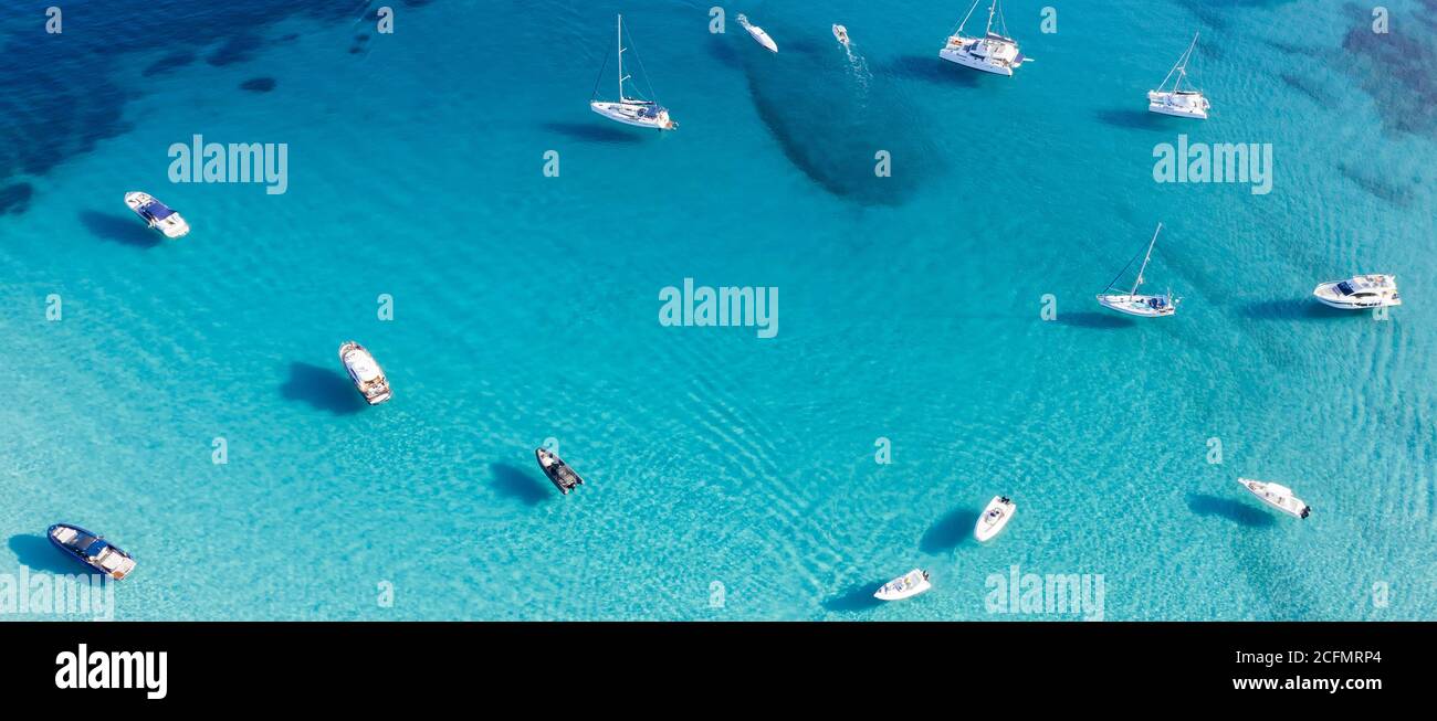 Vista dall'alto, splendida vista aerea di una baia con barche e yacht di lusso a vela su un mare turchese e limpido. Grande Pevero, Sardegna, Italia. Foto Stock