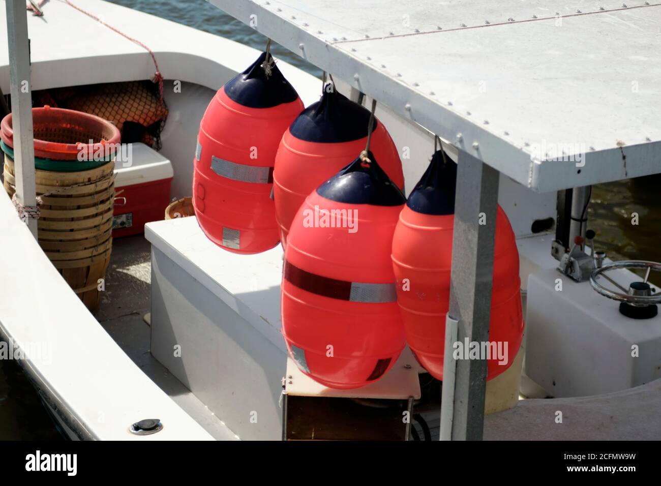 Galleggianti dai colori vivaci appesi su una piccola barca da pesca. Foto Stock