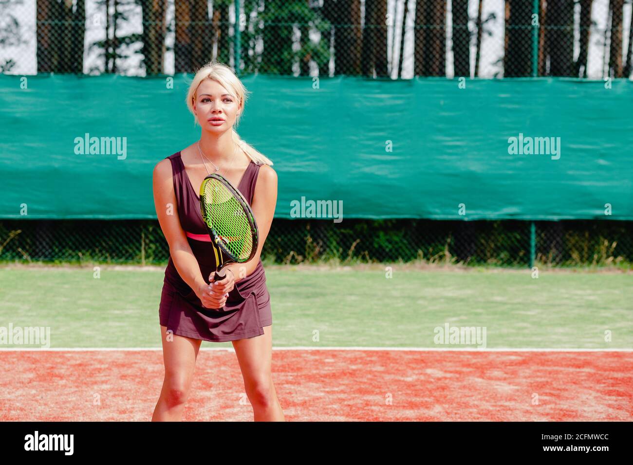 Donna tennista professionista focalizzata in posizione pronta. Una atleta in attesa di servire. Sfida e concentrazione nella concorrenza. Foto Stock