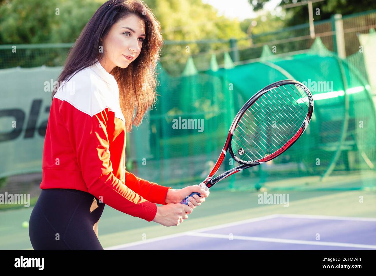 Ritratto di una bella giovane tennista femminile in abbigliamento sportivo  con racchetta da tennis sul campo Foto stock - Alamy