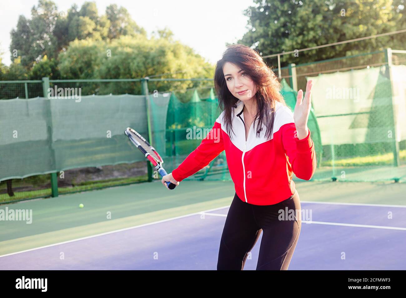 Ritratto di una bella giovane tennista femminile in abbigliamento sportivo con racchetta da tennis sul campo. Foto Stock