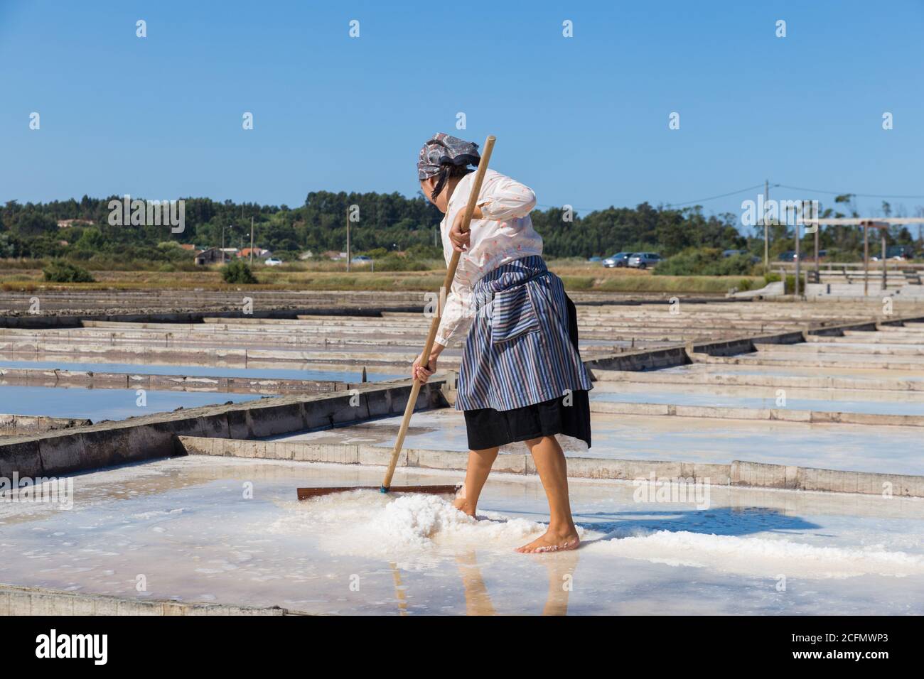 Donna che lavora nella tradizionale estrazione del sale a Figueira da Foz, Portogallo Foto Stock
