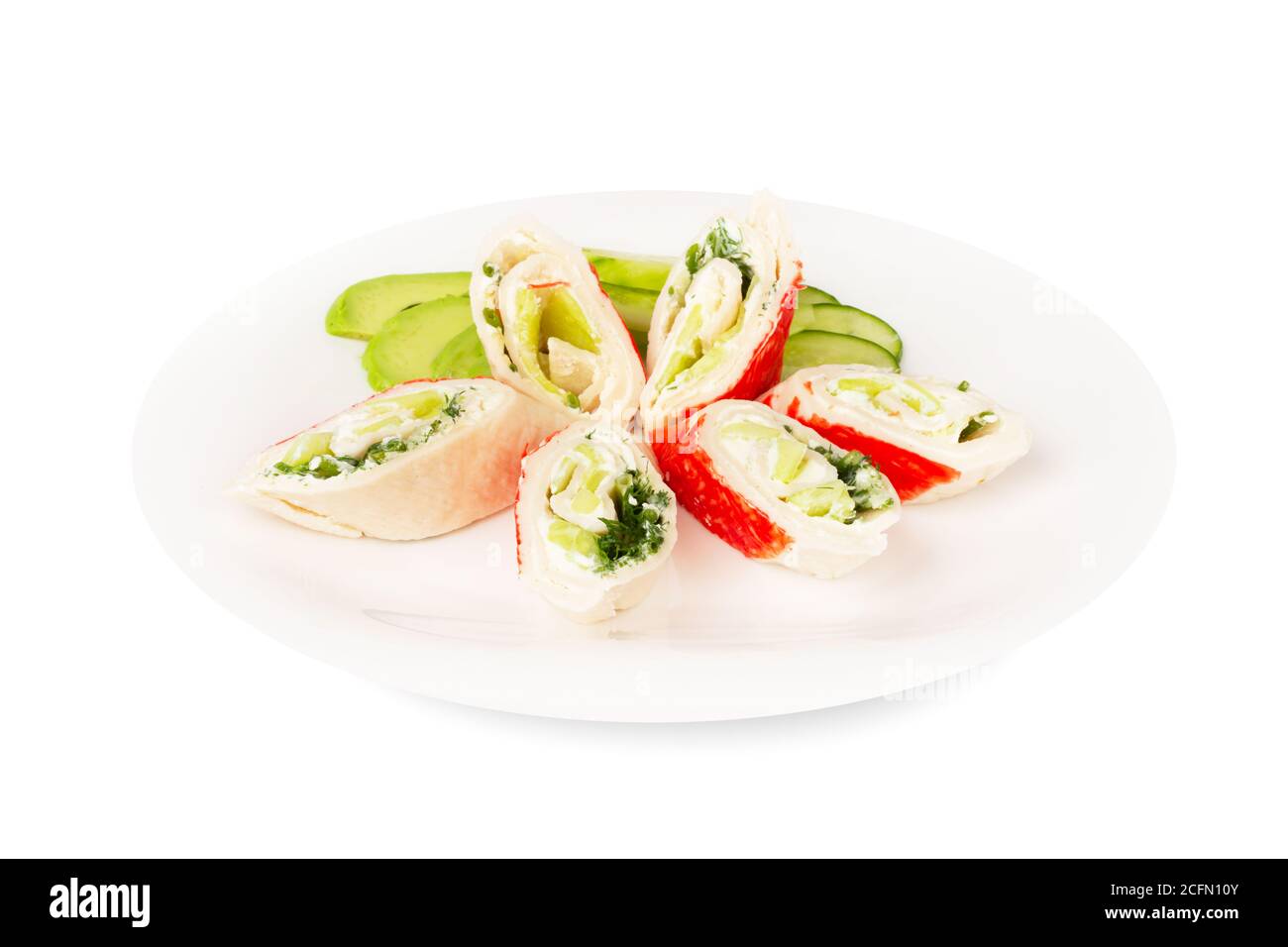 I bastoncini di granchio tagliano i rotoli di carne con salsa di cetrioli di avocado alle verdure su piastra isolata su sfondo bianco Foto Stock