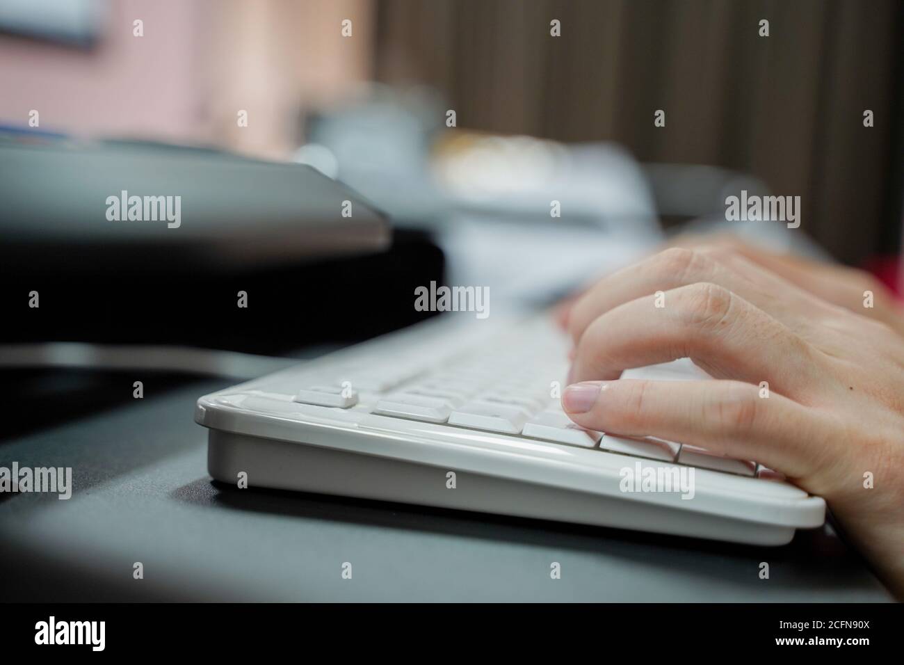 Mano di uomo che scrive sulla tastiera del pc su sfondo sfocato con spazio per la copia Foto Stock
