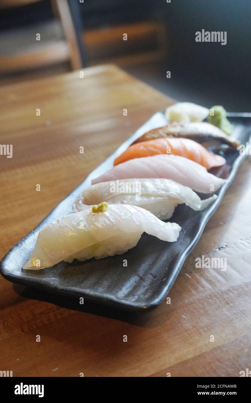 Il nigiri è uno dei tipi più tradizionali di sushi, composto da pesce fresco o verdure bevuto su piccole cialde di riso di sushi stagionato. Foto Stock