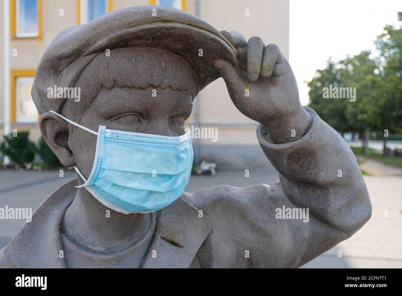 Ritorno a scuola per bambini e studenti durante COVID-19 o l'epidemia di Coronavirus, ritorno a scuola con nuove regole, statua di bambino che indossa una maschera Foto Stock