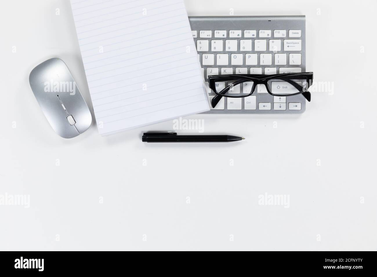 Visualizzazione di una parola chiave con un notebook, una penna e occhiali su sfondo bianco Foto Stock