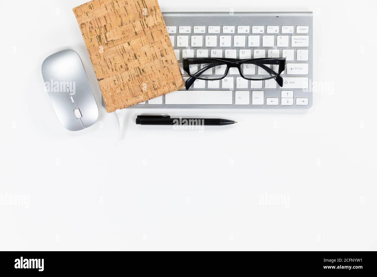 Visualizzazione di una parola chiave con occhiali e un notebook con una penna su sfondo bianco Foto Stock