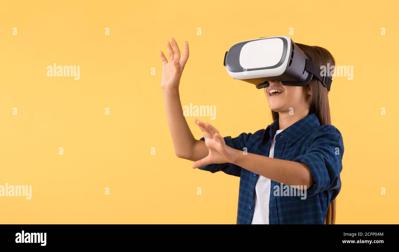 Bambina che indossa occhiali per realtà virtuale presso lo studio arancione Foto Stock