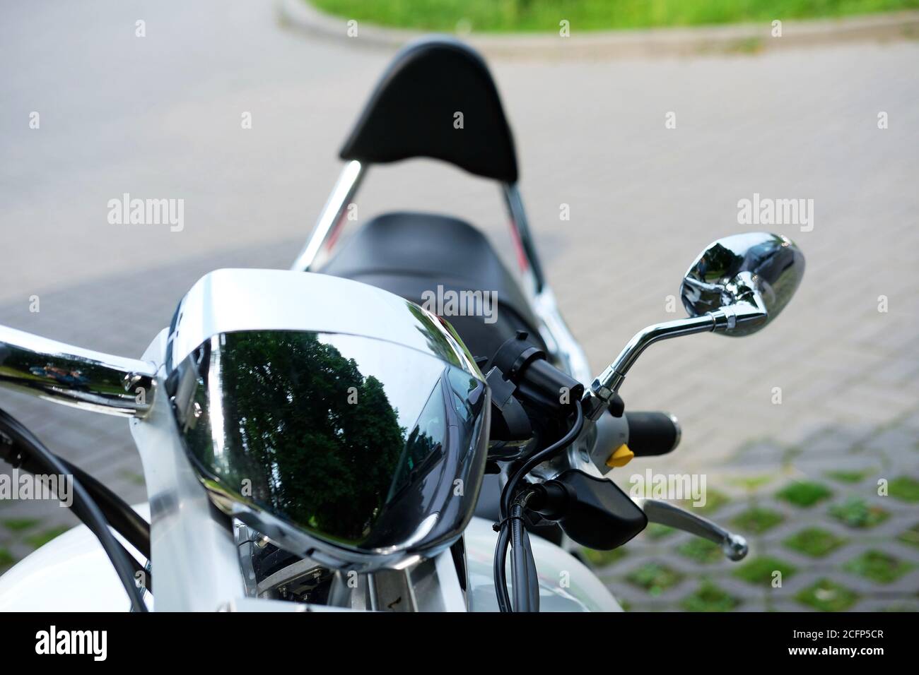 Primo piano di un classico corrimano per moto e di un faro e di uno specchio cromati. Foto Stock