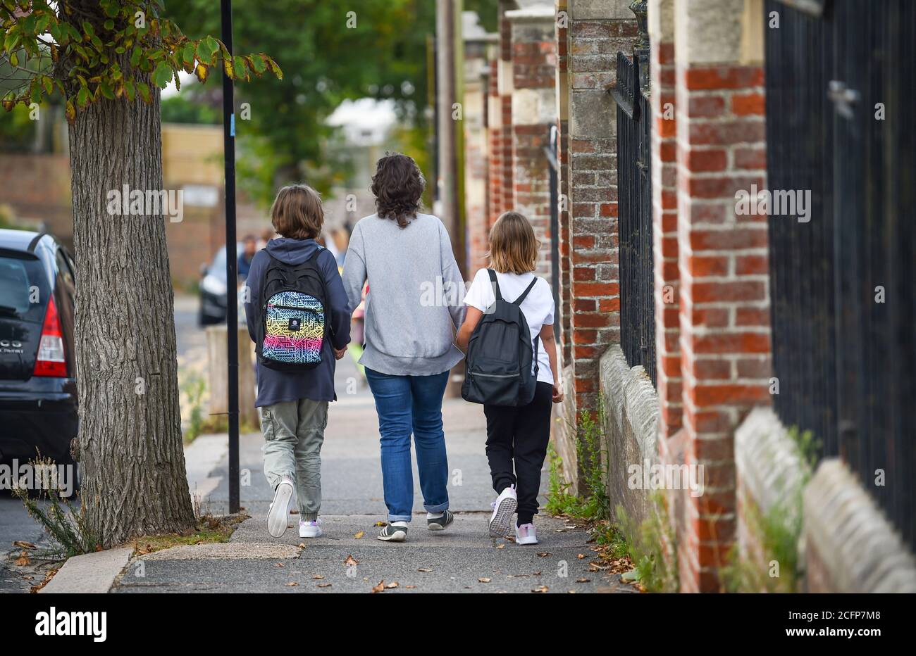 Brighton UK 7 settembre 2020 - Rachael Holdsworth con le figlie Romy (10) a sinistra e Bodil (8) mentre alunni e genitori tornano alla St Luke's Primary School di Brighton questa mattina, dove la strada è stata chiusa per aiutare con le distanze sociali e la sicurezza stradale al loro ritorno istruzione . Il nuovo Schema di Via della Scuola è stato introdotto a quattordici scuole dal consiglio comunale per l'inizio del termine in settembre ed è applicato due volte al giorno per un'ora tra le 8-2-4 e le  : Credit Simon Dack / Alamy Live News Foto Stock