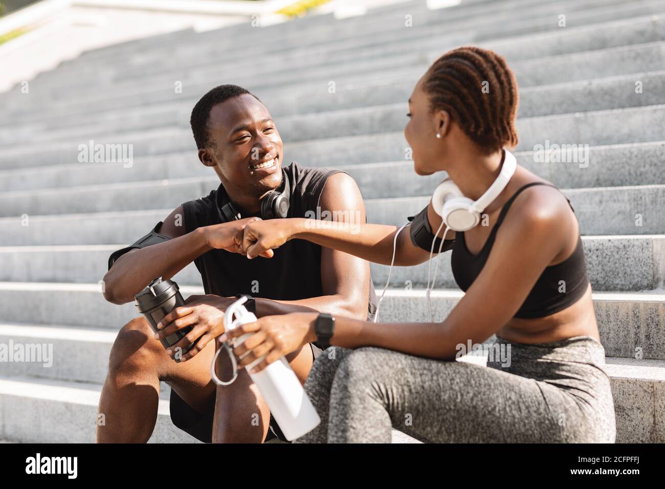 Buon partner di lavoro. Black Athlete Guy e Girl Fist-Bumping dopo l'allenamento all'aperto Foto Stock