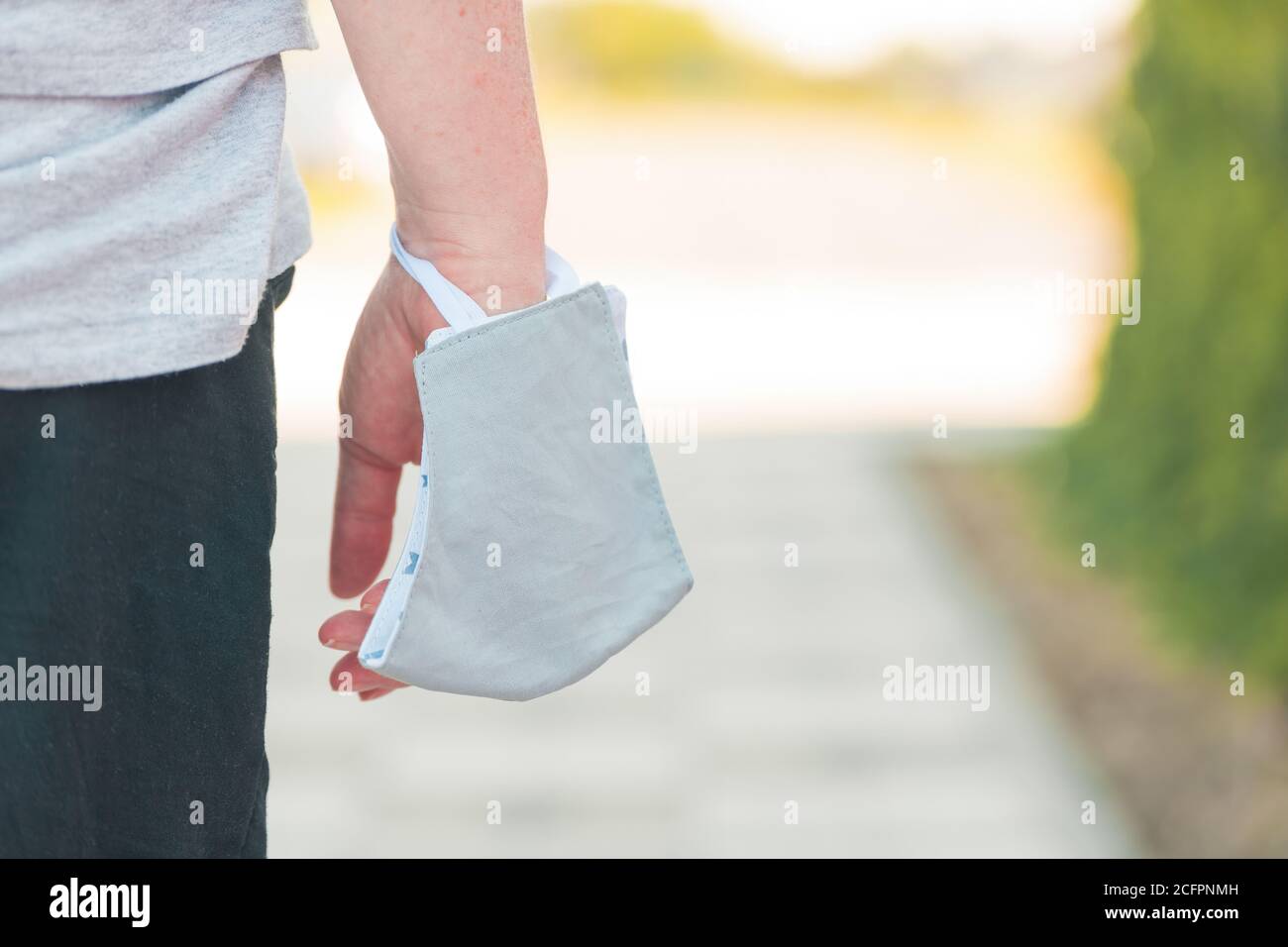 Donna che indossa una maschera protettiva intorno al polso durante le pandemie del virus della corona, fuoco selettivo Foto Stock