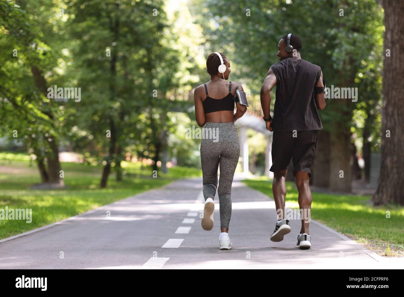 Jogging mattutino. Coppia attiva Black che corre nel parco estivo, vista  posteriore Foto stock - Alamy