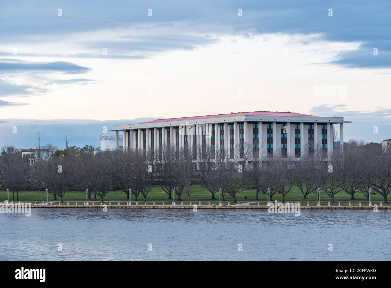 Le nuvole di mattina formano un alone sopra la Biblioteca Nazionale sulle rive del Lago Burley Griffin a Canberra, territorio della capitale australiana Foto Stock