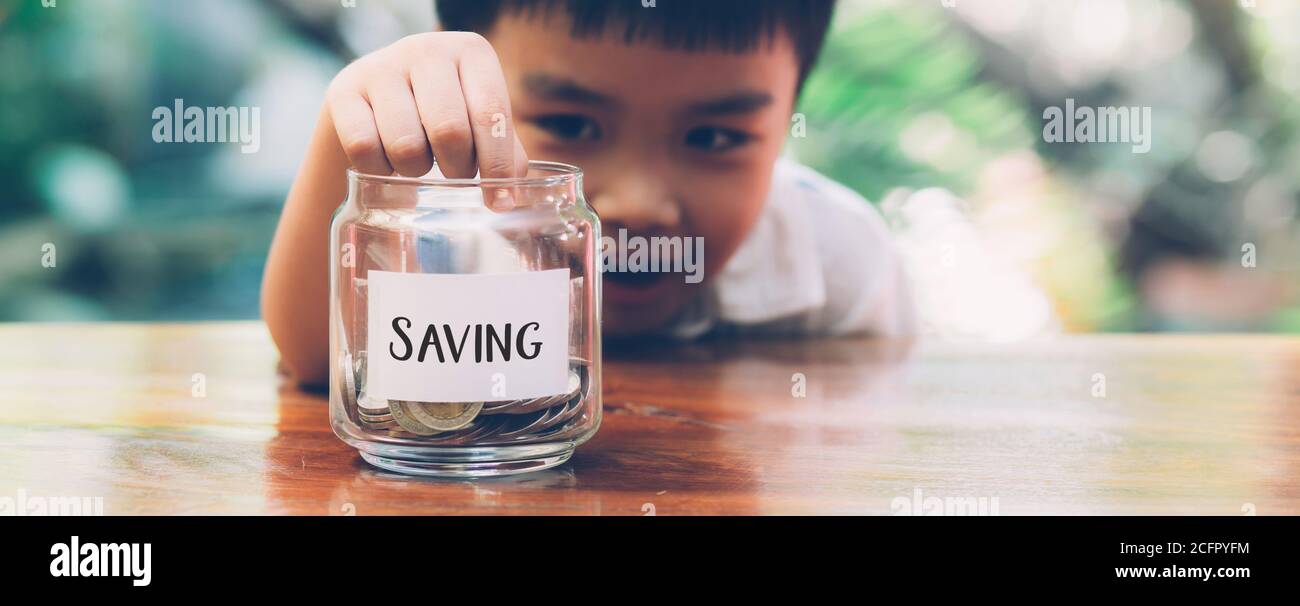 Felici i bambini asiatici risparmiare denaro mettere moneta in vetro per la ricchezza e la crescita di guadagno, la finanza e gli investimenti per il successo, la pianificazione dei ragazzi e il deposito Foto Stock