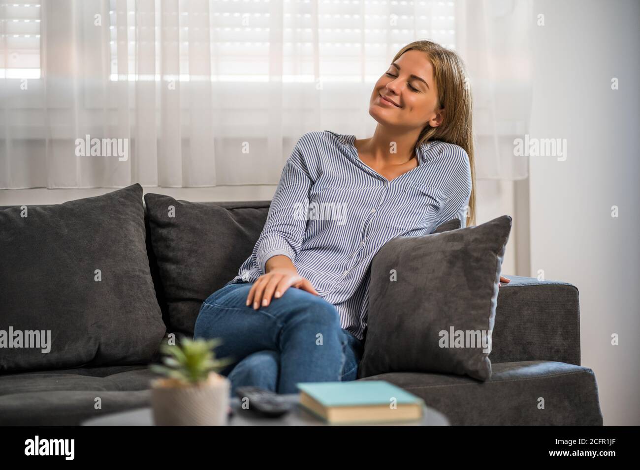 La giovane donna si rilassa a casa. Foto Stock