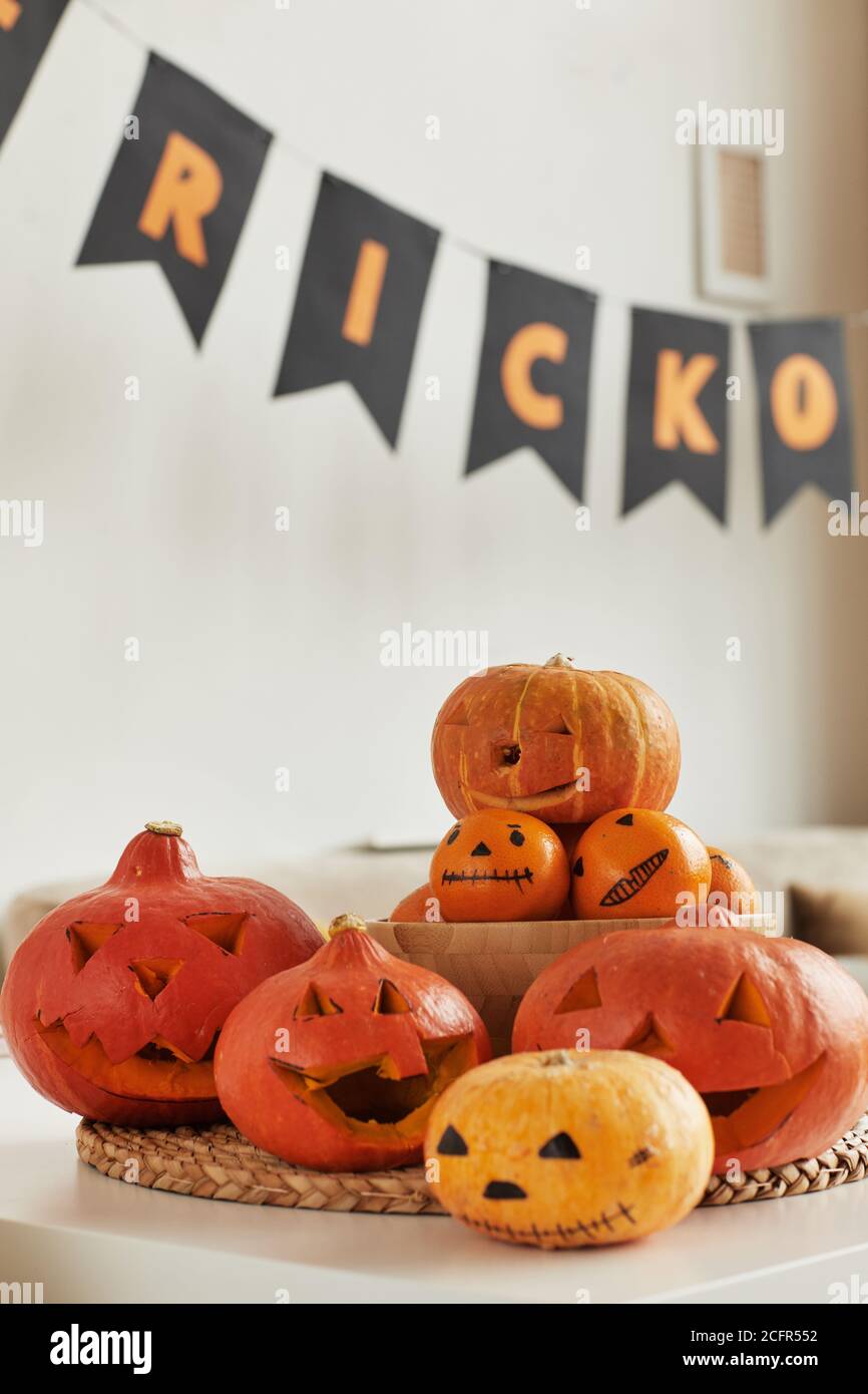 Gruppo di zucche intagliate e tangerini con volti spooky preparati per Halloween festa a casa, nessuna gente sparata Foto Stock