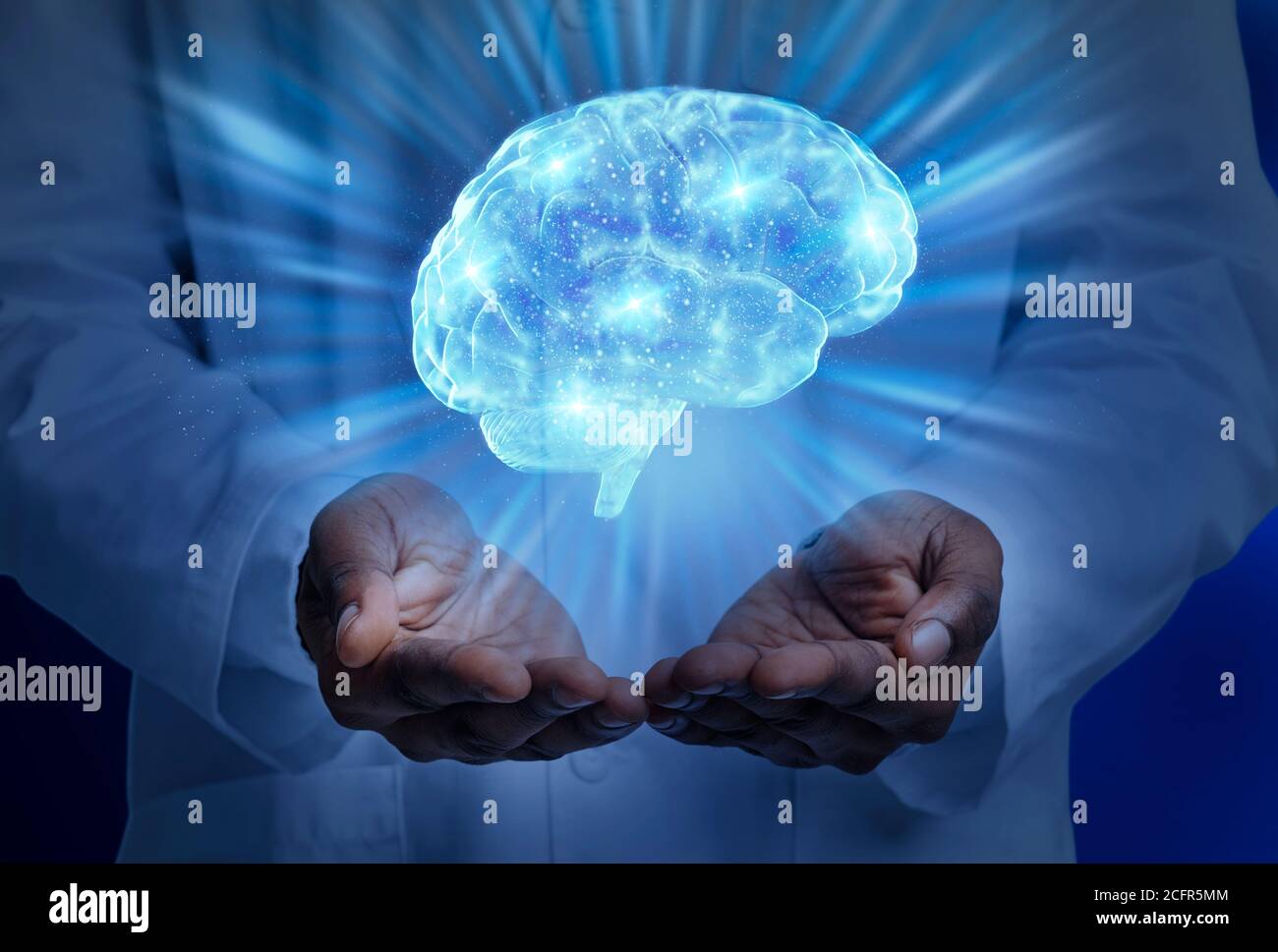 Medico nero in bianco che tiene illuminato cervello umano Foto Stock