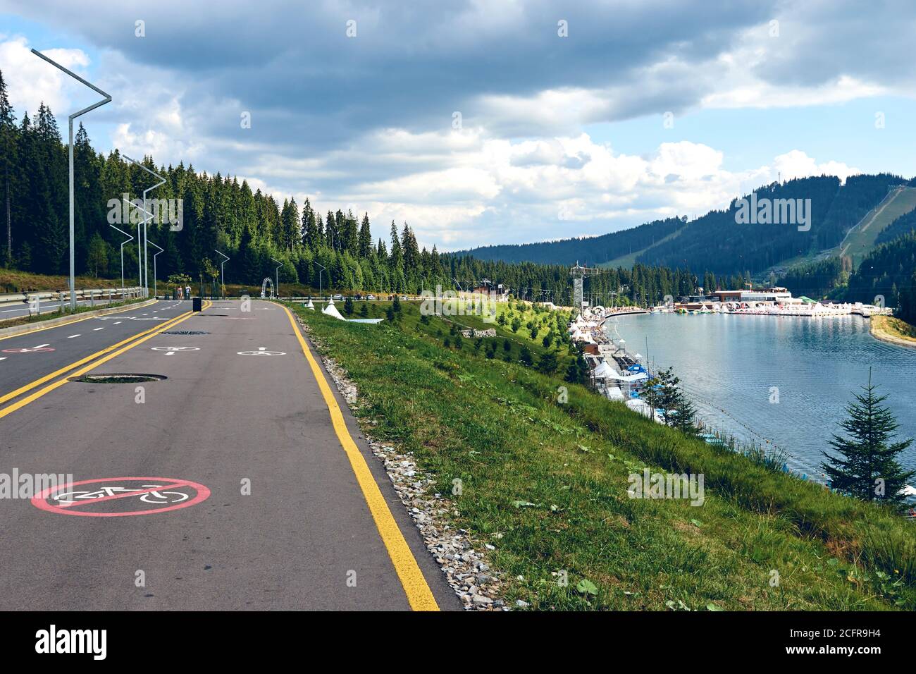 Vista panoramica della pista ciclabile e della strada solo per i pedoni. Cartello ciclabile lungo la foresta di montagna lago resort Foto Stock