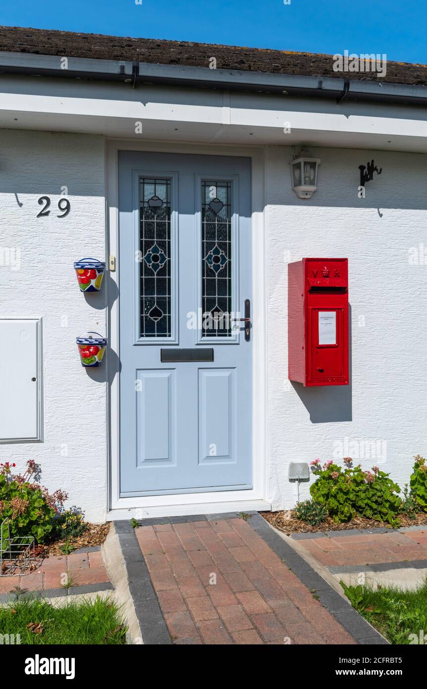 La porta anteriore di una casa residenziale con la propria parete personale montata scatola postale Royal Mail rossa, in Inghilterra, Regno Unito. Lo stile è vittoriano, ma forse replica. Foto Stock La porta anteriore di una casa residenziale con la propria parete personale montata scatola postale Royal Mail rossa, in Inghilterra, Regno Unito. Lo stile è vittoriano, ma forse replica. Foto Stock
