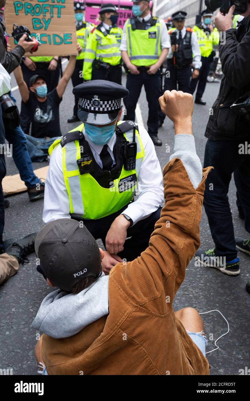 Il protetore solleva il pugno alla polizia, Animal Rebellion Road Block fuori del Department of Health and Social Care, Londra, 3 settembre 2020 Foto Stock