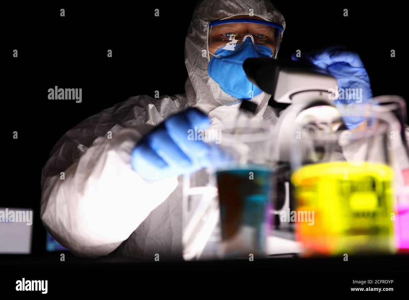 Un uomo in laboratorio guarda attraverso un microscopio Foto Stock