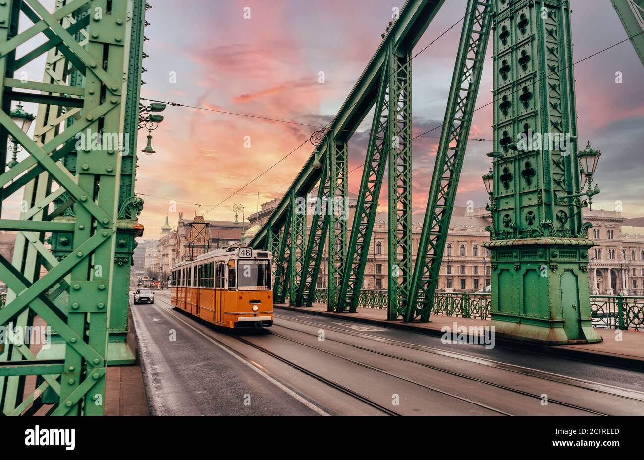 Tram storico sul Ponte della libertà a Budapest, Ungheria. Città al tramonto Foto Stock