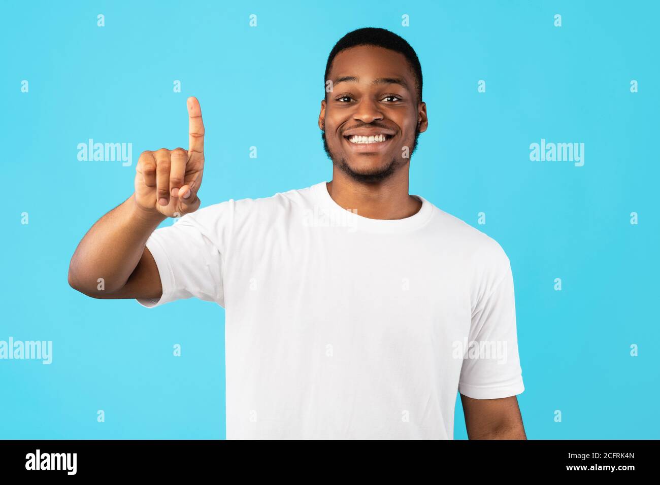Sorridente Black Guy che mostra il numero uno con dito, Studio Shot Foto Stock