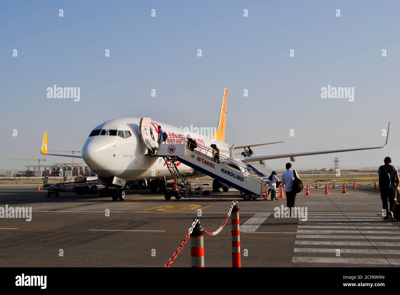 Nicosia del Nord, Cipro del Nord. Un aereo che sta per imbarcarsi  dall'Aeroporto Internazionale di Ercan. Passeggeri turistici a piedi per  l'aereo Foto stock - Alamy