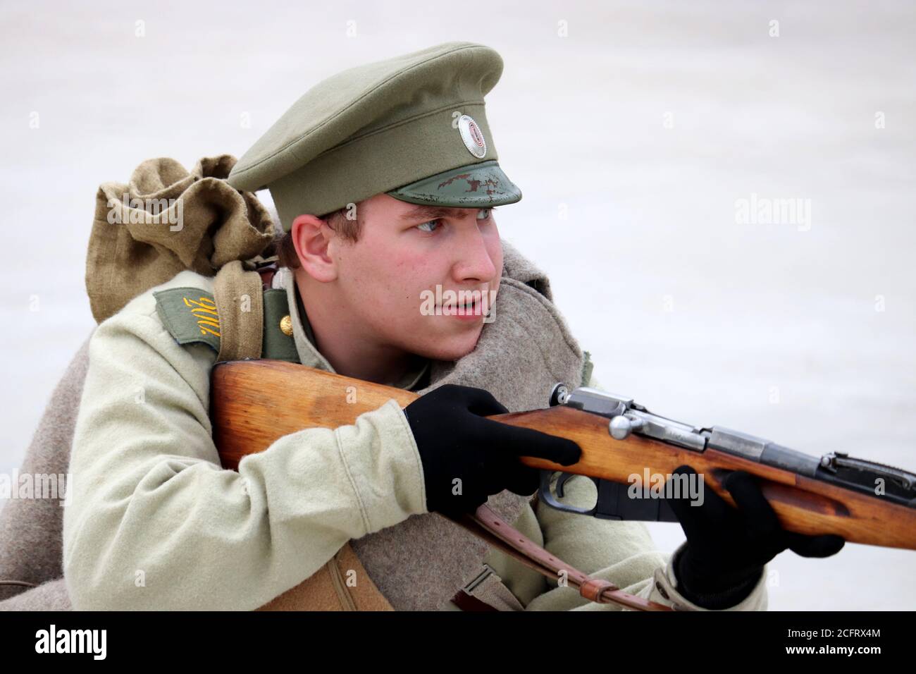 Soldato dell'Impero Russo degli inizi del XX secolo che mira a un fucile durante il giorno della città di Mosca nel parco Mitino. Ricostruzione storica Foto Stock