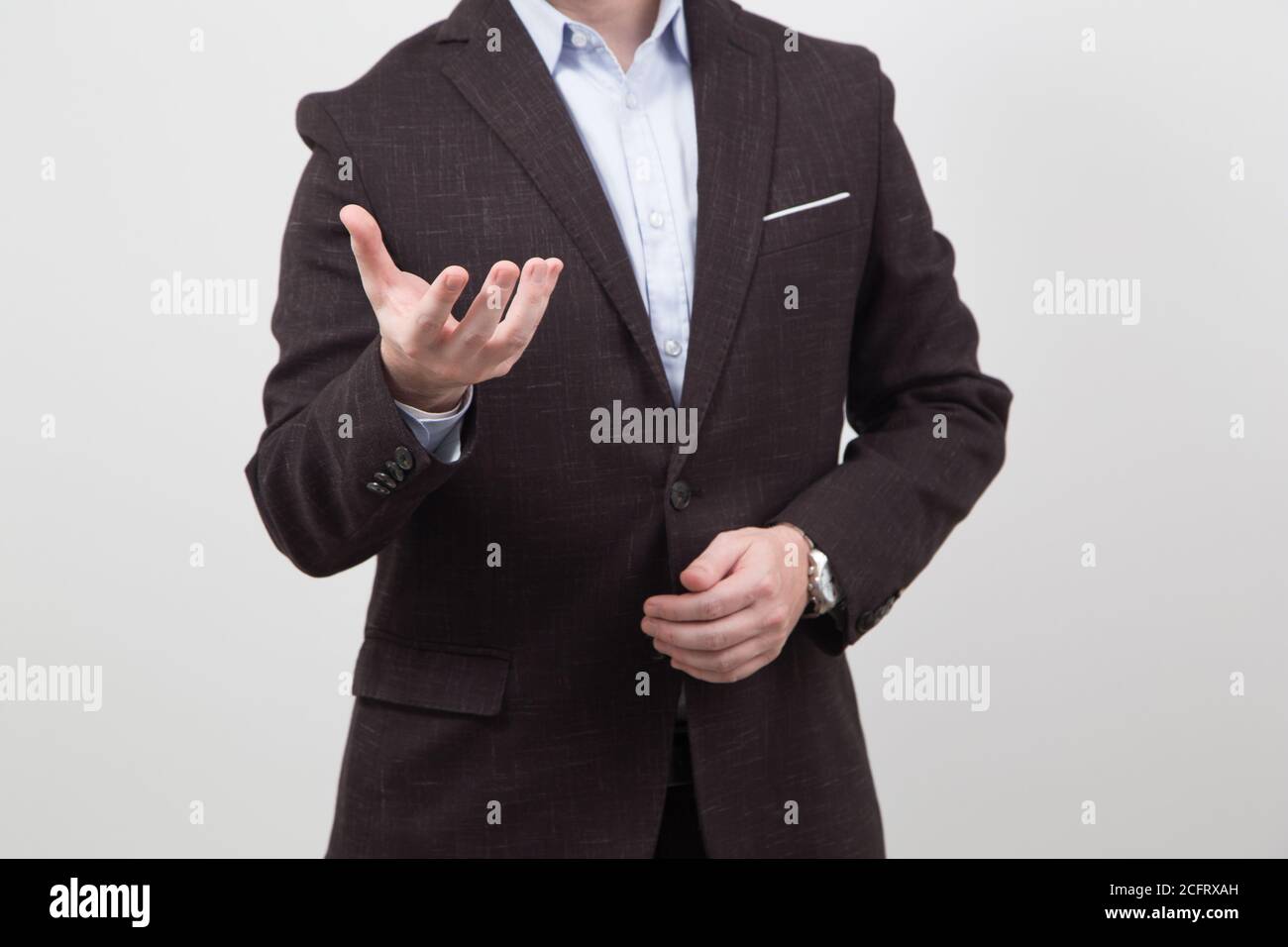persona in abito nero e camicia bianca, mostrando la mano e l'altro sui suoi vestiti Foto Stock